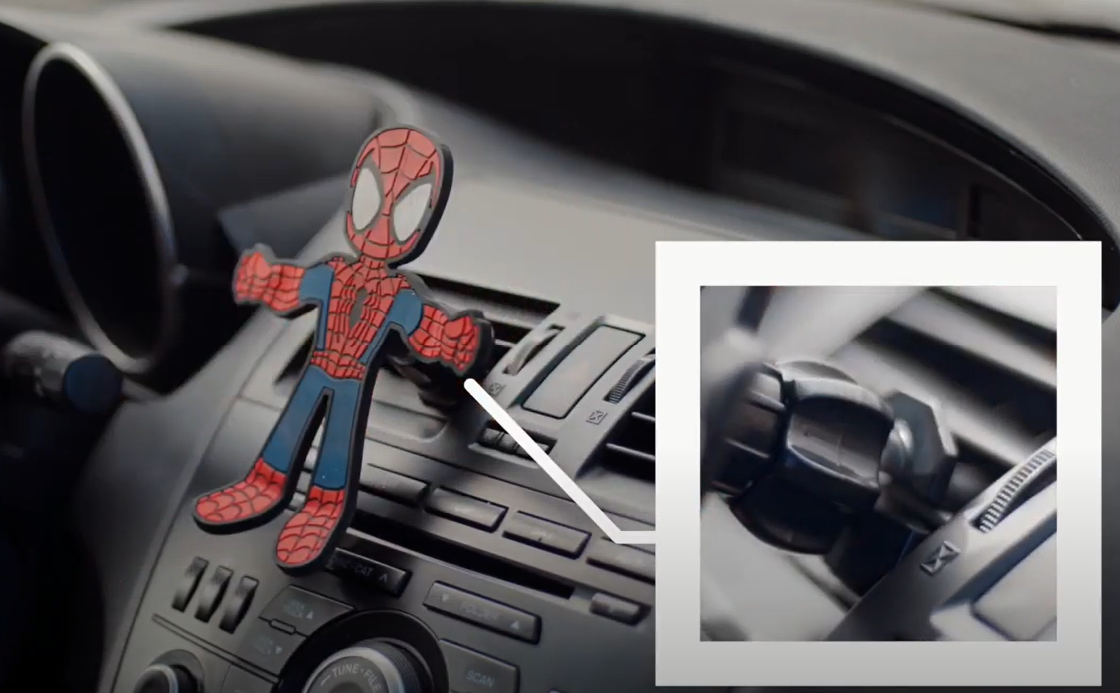 Image of Spider-Man being installed to the air vent in a vehicle