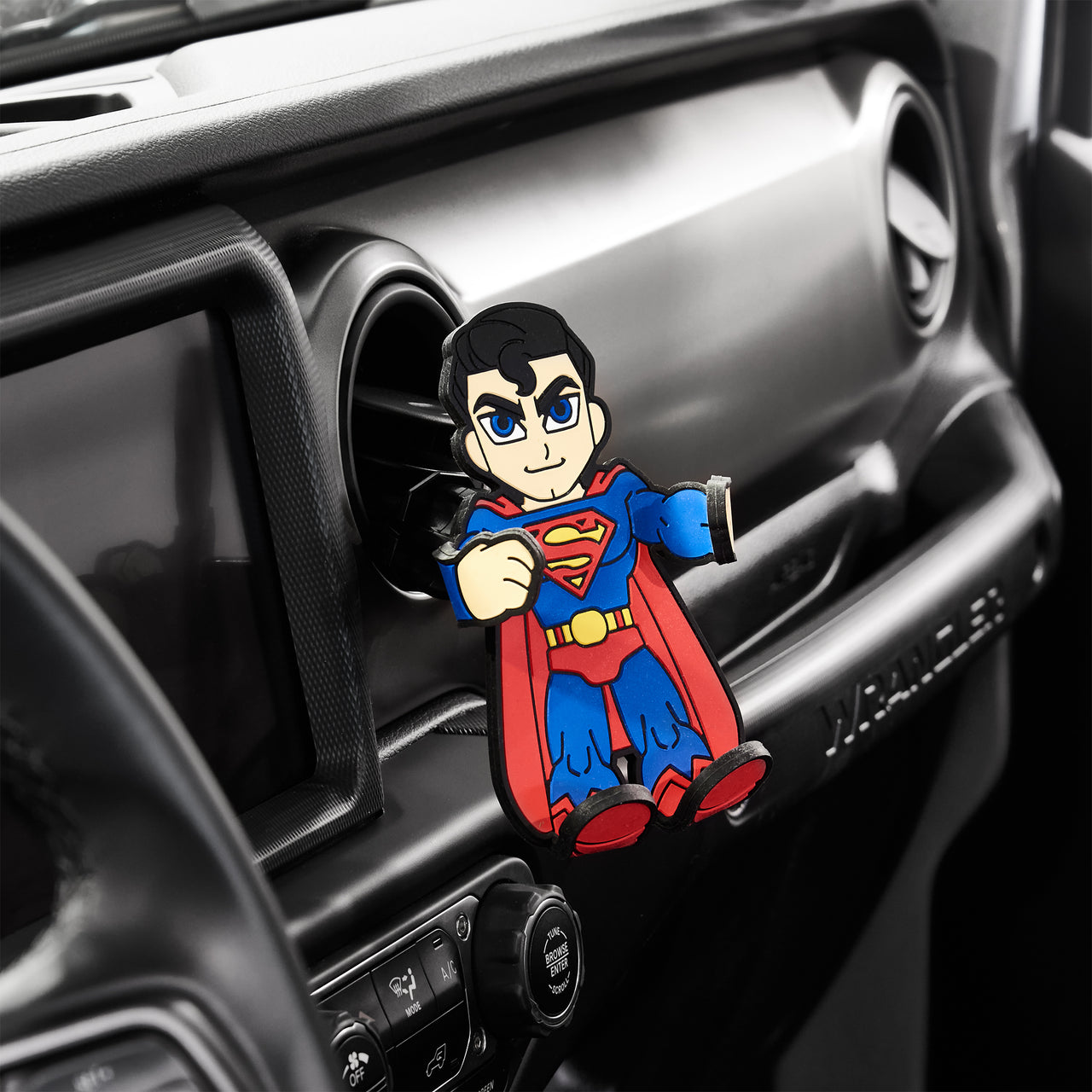 Image of DC Comics Superman Hug Buddy attached to a car air vent with arms and legs in the closed position ready to fly away with your cell-phone or smart device