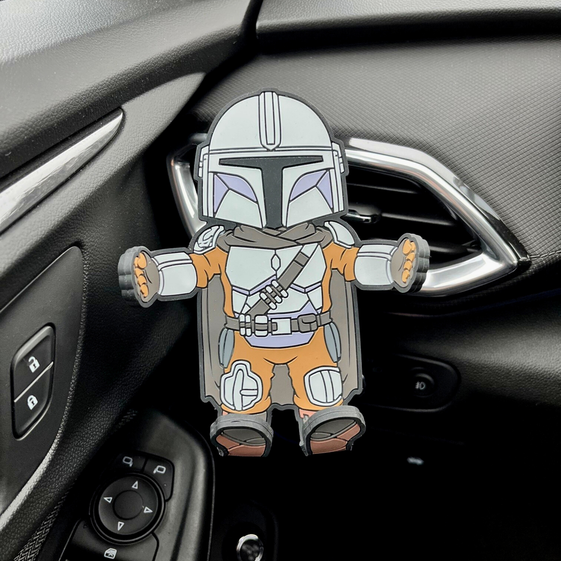 Image of Star Wars The Mandalorian Hug Buddy in a car attached to the air vent, with arms and legs spread open