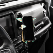 Image of Star Wars the Mandalorian Grogu Hug Buddy attached to a car air vent holding a cell phone