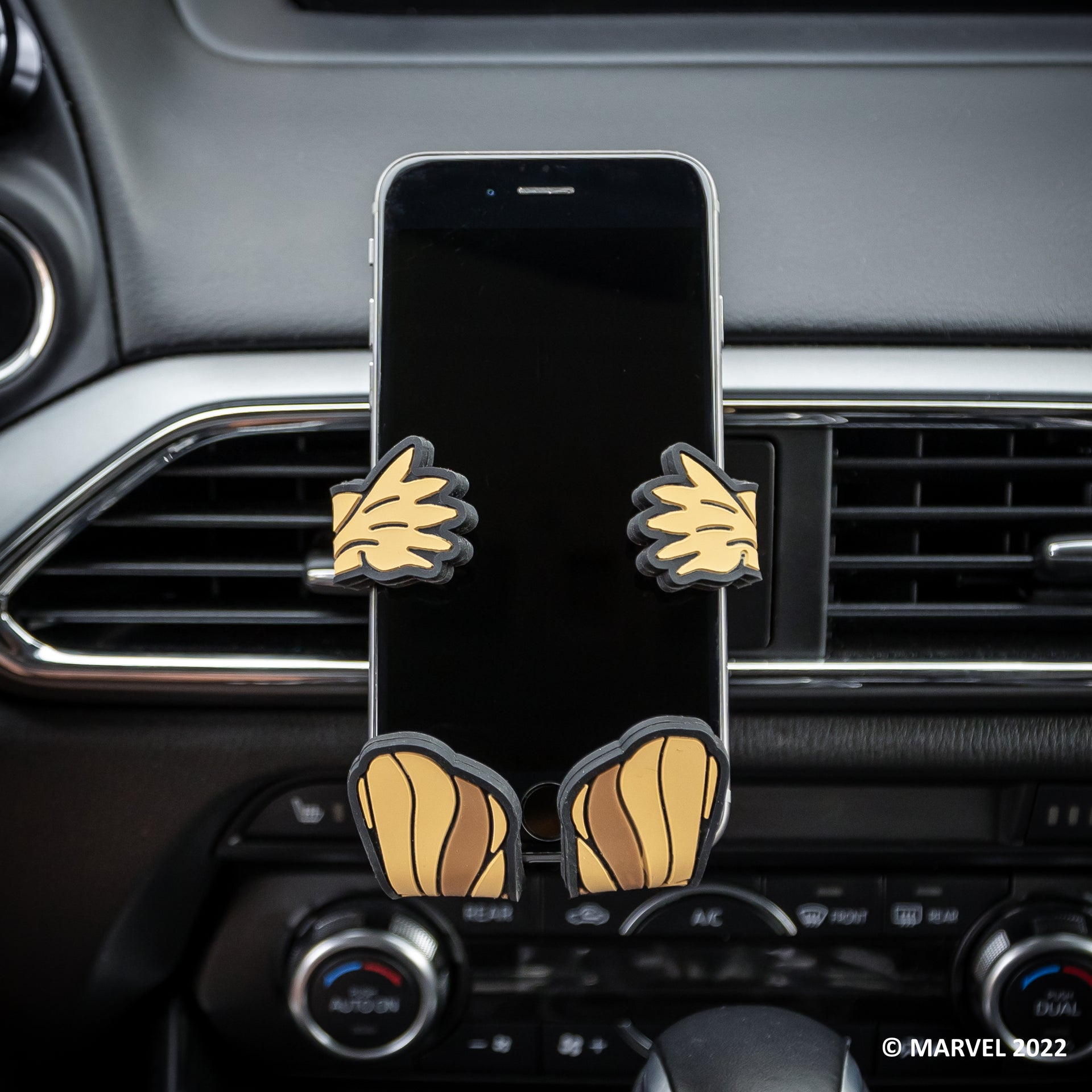 Image of Marvel Groot Hug Buddy attached to a car air vent, holding a cell phone