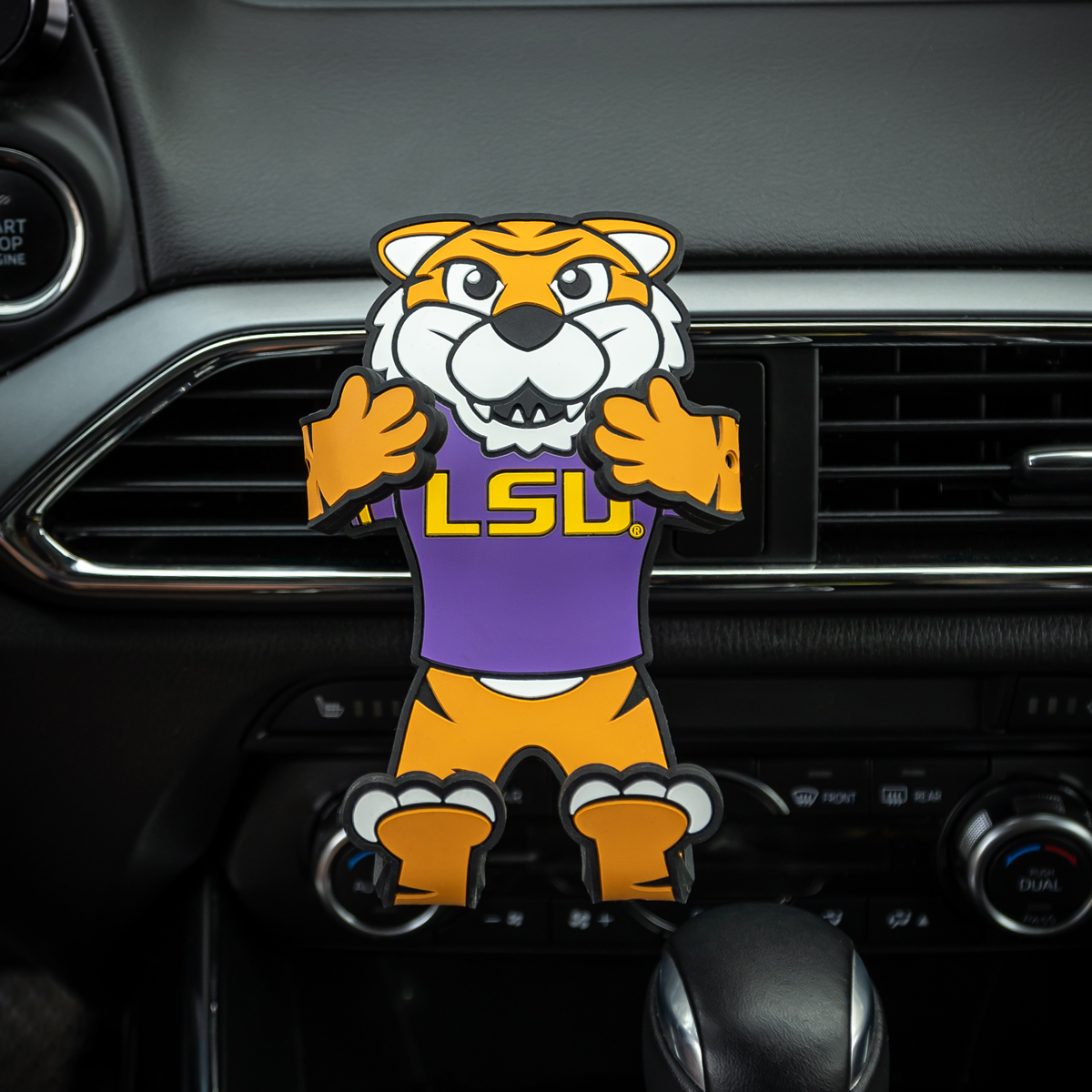 Image of NCAA LSU Tiger Hug Buddy attached to a car air vent with arms and legs in the folded closed position ready to hold a phone, GPS, or other smart device