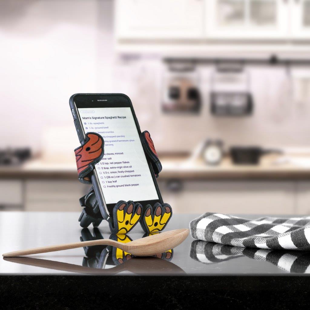 Image of Stripes the Eagle Hug Buddy holding a phone on top of a kitchen counter with a recipe displayed on the phone screen