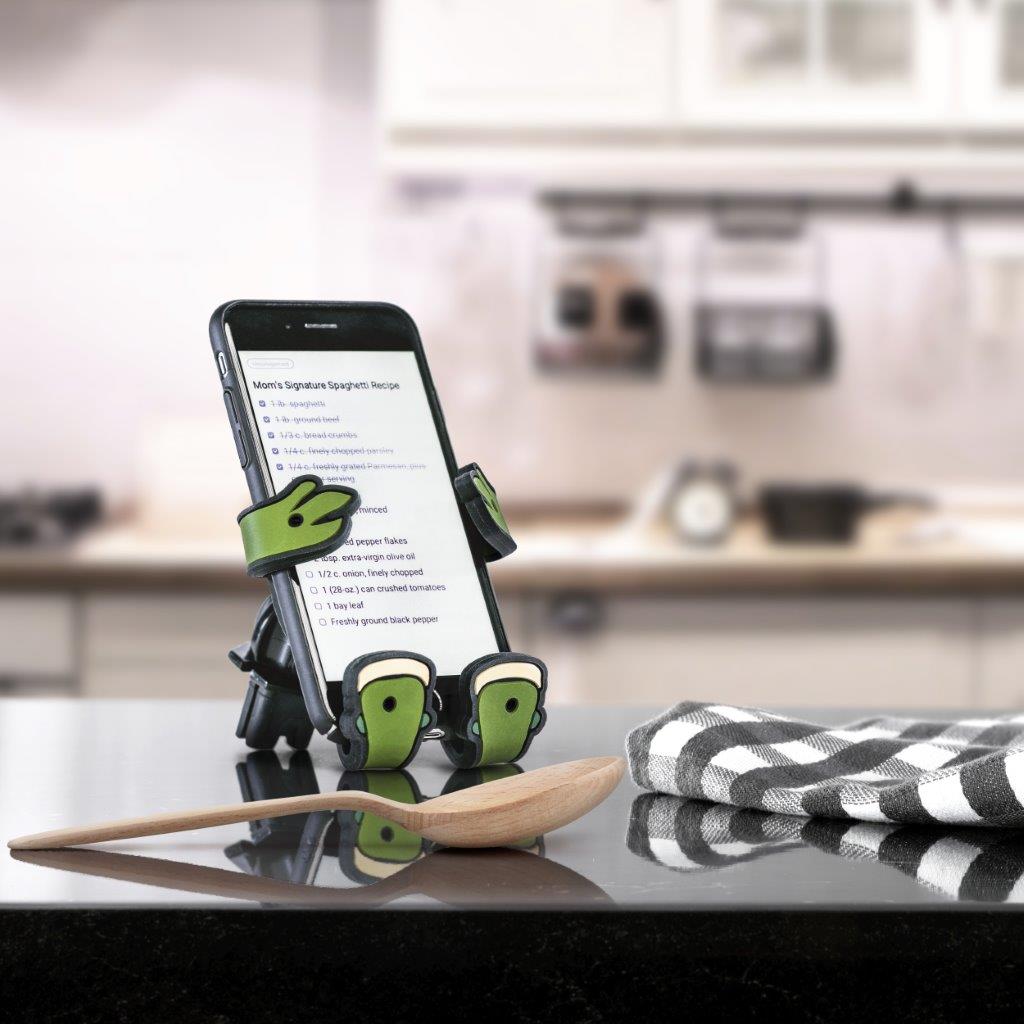 Image of Shellebrity the Turtle Hug Buddy holding a cell phone with a recipe on the screen, on top of a kitchen counter