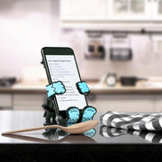 Image of the Yeti Hug Buddy sitting on a kitchen island with a cell phone in its grasp displaying a new recipe to try out!