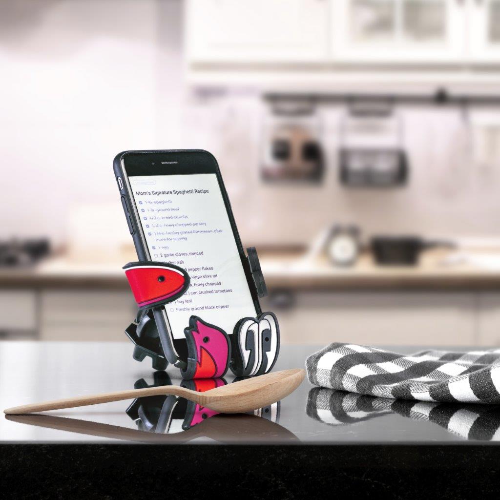 Image of Shaky the fish bait Hug Buddy holding a cell phone on top of a kitchen counter