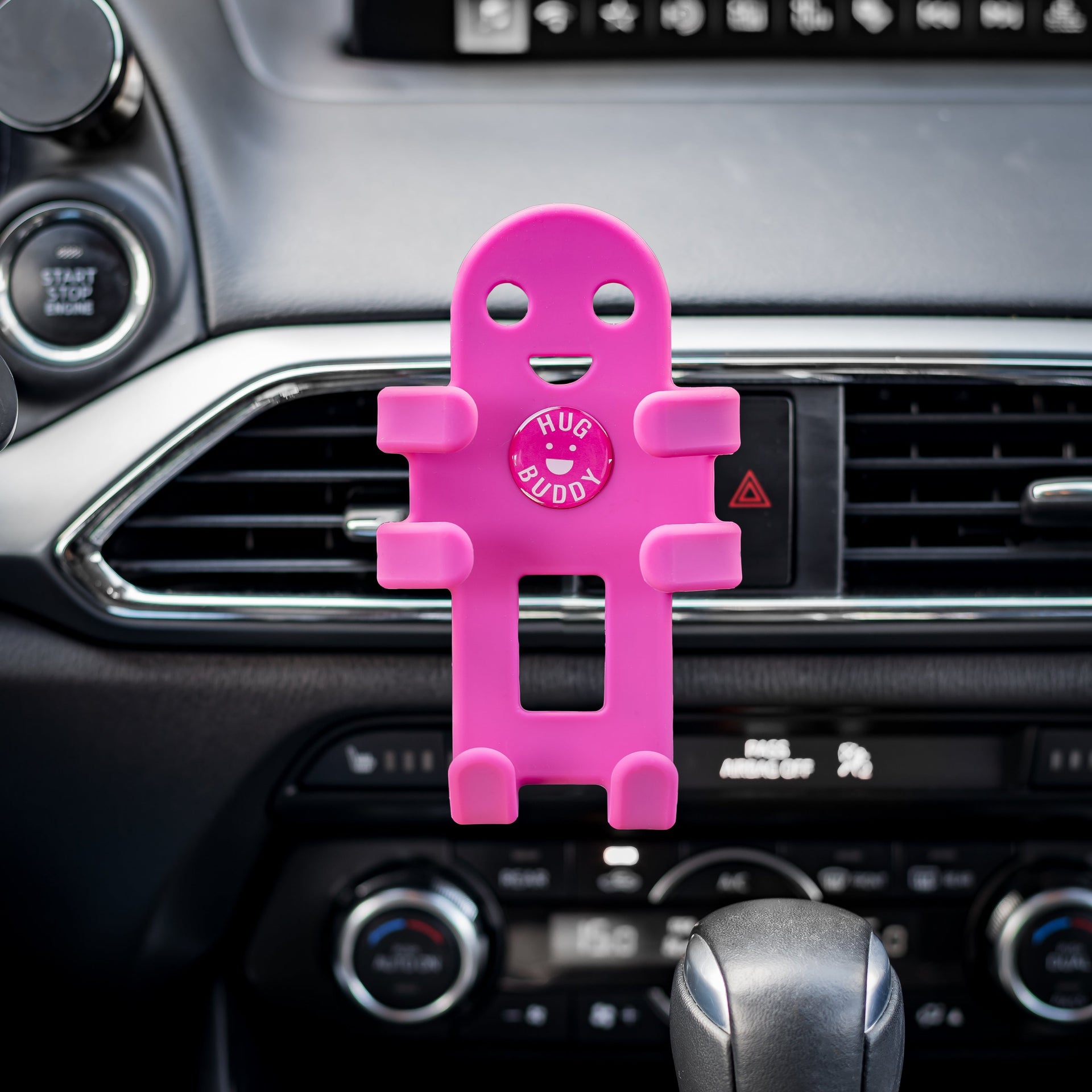 Image of OG Pink Hug Buddy with arms and legs in the closed position, ready to hold a cell phone on your next journey, while attached to a vehicle air vent