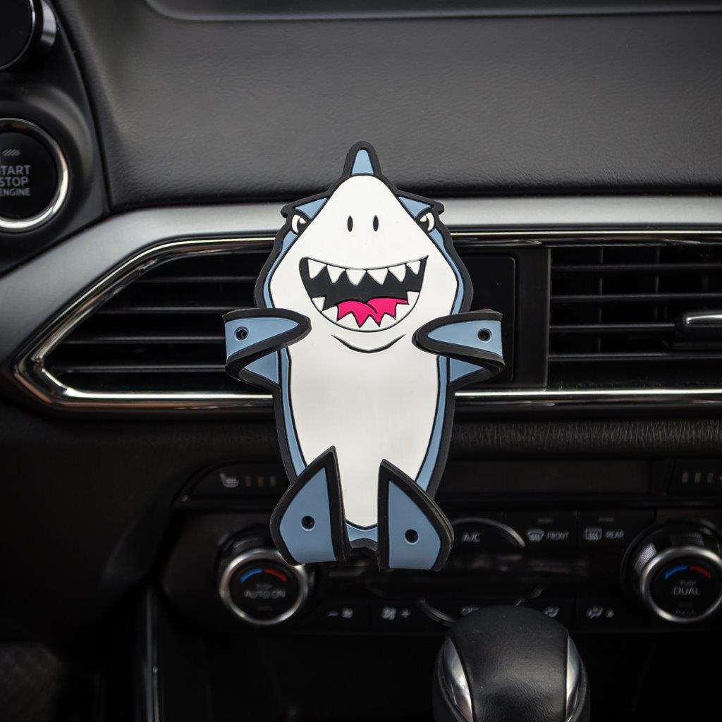 Image of Jaws the Shark Hug Buddy attached to a vehicle air vent with arms and legs folded in the closed position ready to grasp a phone or other smart device