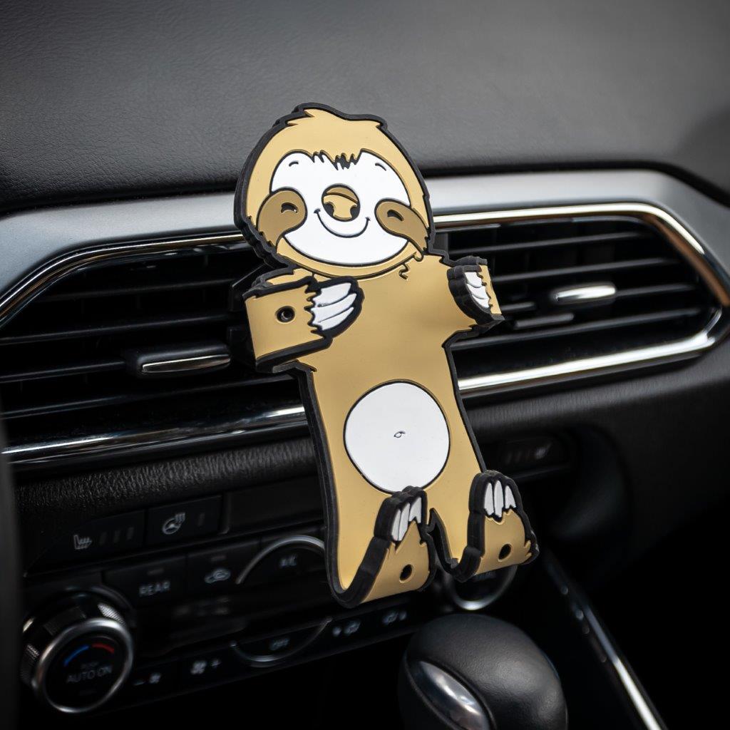 Image of Sloth Hug Buddy attached to a car air vent with arms and legs folded in, ready to grasp your smart phone or GPS