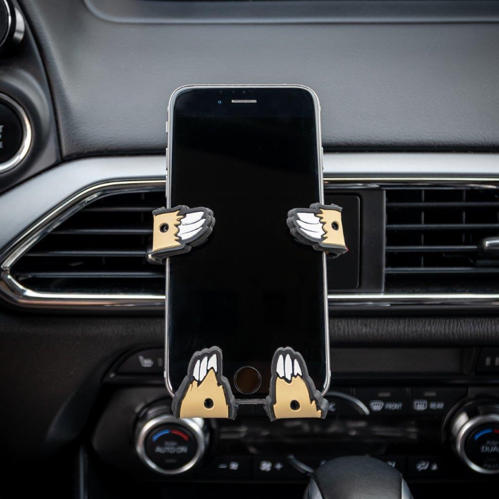 Image of Sloth Hug Buddy attached to a vehicle air vent holding a cell phone