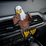 Image of Stripes the Eagle Hug Buddy attached to a car air vent with arms and legs in the closed position, ready to hold a phone or GPS or other smart device