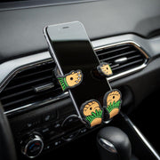 Image of Hula Girl Hug Buddy attached to a car air vent, holding a cell-phone
