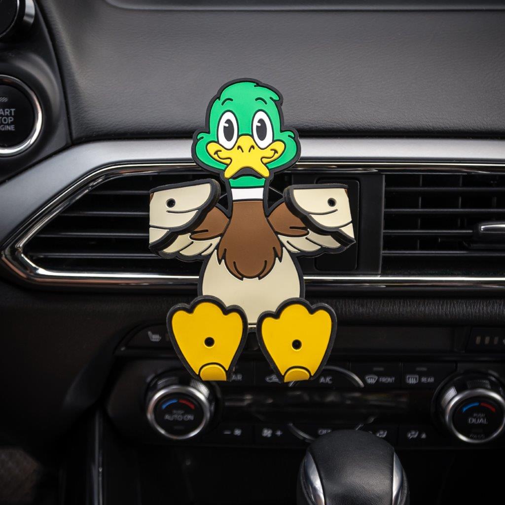 Image of Crumbs the duck Hug Buddy attached to a car air vent with arms and legs folded inward ready to hold onto a smart device or cell-phone during your next journey