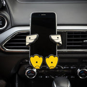 Image of Crumbs the duck Hug Buddy attached to a vehicle air vent holding a cell phone